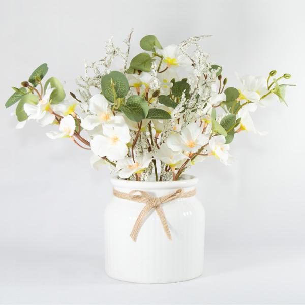 Florero con flor de cerezo y eucalipto